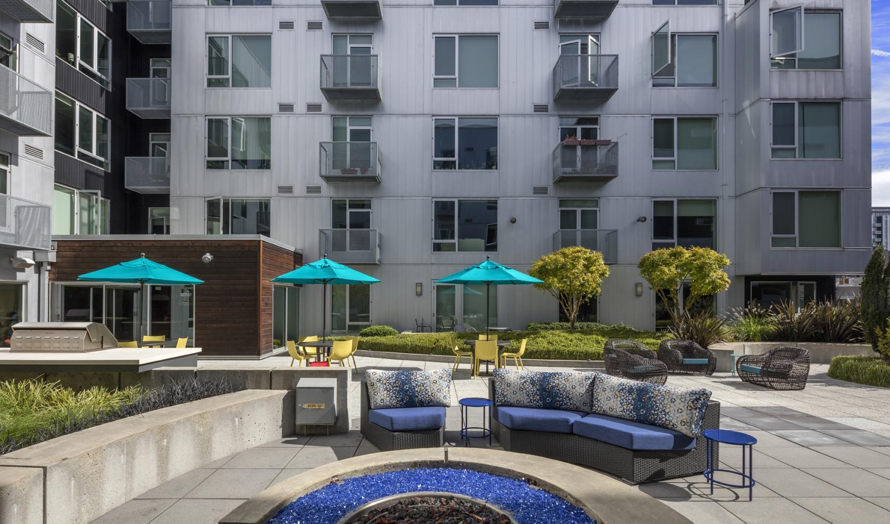 Take advantage of all Enso has to offer patio lounge area in apartment courtyard with umbrella coverings