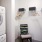 a room with a washing machine a chair and shelves